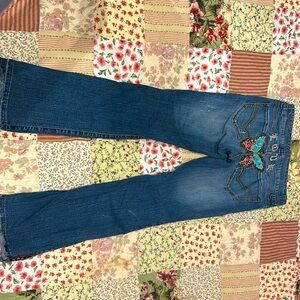 2000s/y2k low rise blue jeans with butterfly design on the butt.